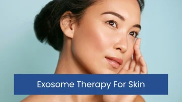 Close up of a serene woman touching her cheek with a soft smile, set against a light blue background. Text overlay: "Exosome Therapy For Skin."